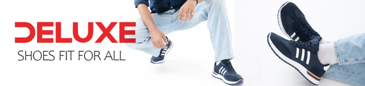 Lifestyle image of a model wearing Deluxe navy blue lace-up casual sneakers with white stripe design, cushioned sole, and lightweight comfort for everyday wear